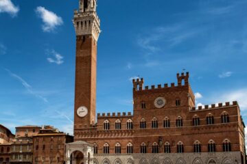 Siena's Palazzo Pubblico and Torre del Mangia in the vibrant Piazza del Campo, Italy.